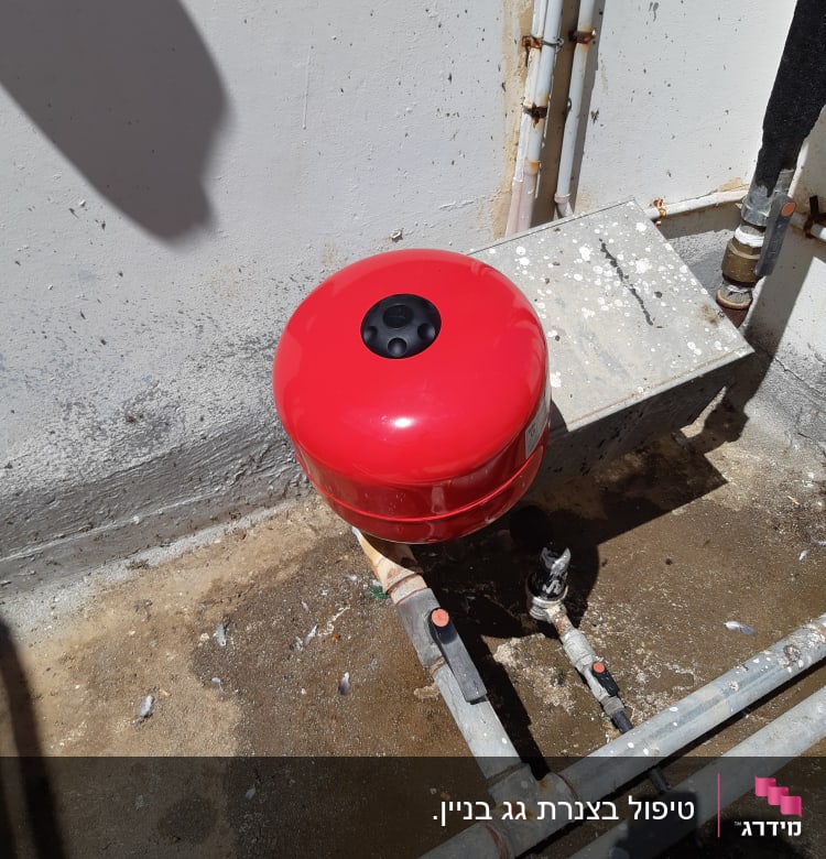 מיכל לחץ אדום וצינורות מתכת עם ברזים